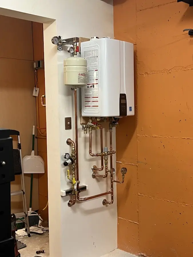 Plumbing technician inspecting water heater connections in Upper Frederick